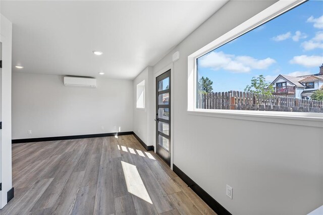 861 9th St W, Kalispell, MT 59901 - spare room with a wall unit AC, recessed lighting, and wood finished floors