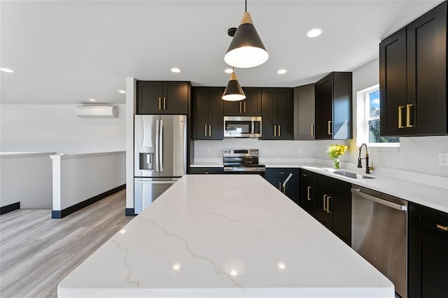 861 9th St W, Kalispell, MT 59901 - kitchen with appliances with stainless steel finishes, a center island, light wood finished floors, decorative light fixtures, and a wall mounted AC