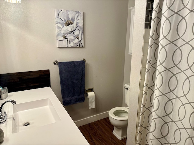 bathroom featuring toilet, a sink, wood finished floors, baseboards, and a shower with shower curtain