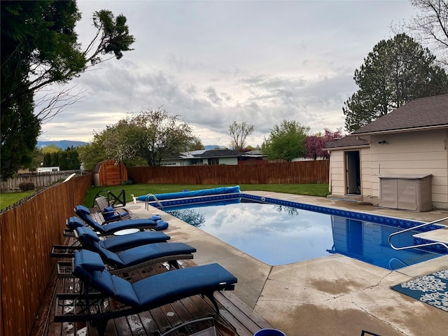 view of pool with a storage shed and an outdoor structure