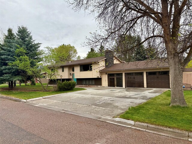 1765 Cyprus Ct, Missoula, MT 59801 - view of front of property with concrete driveway, a garage, a front yard, and a chimney