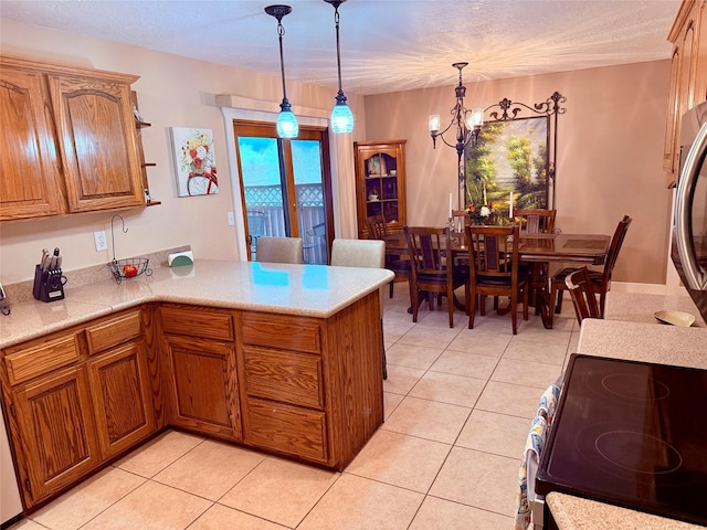 kitchen with a peninsula, light tile patterned flooring, light countertops, and a chandelier