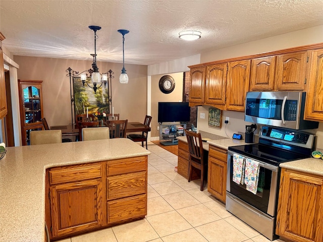 kitchen with appliances with stainless steel finishes, light countertops, brown cabinetry, a chandelier, and a textured ceiling