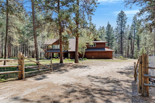 303 Wyant Ln, Hamilton, MT 59840 - view of front of property featuring fence, driveway, a shingled roof, and a view of trees