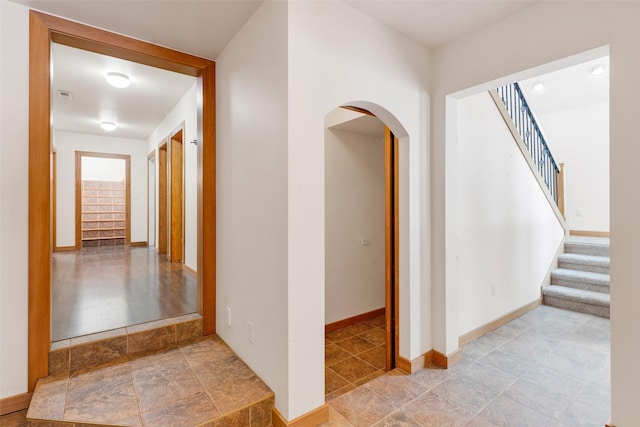 303 Wyant Ln, Hamilton, MT 59840 - hallway with arched walkways, stairway, baseboards, and stone finish floors