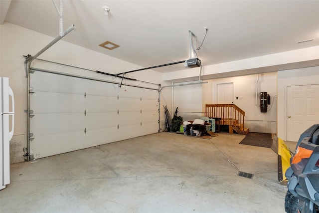 303 Wyant Ln, Hamilton, MT 59840 - garage with a garage door opener, a central vacuum unit, and freestanding refrigerator