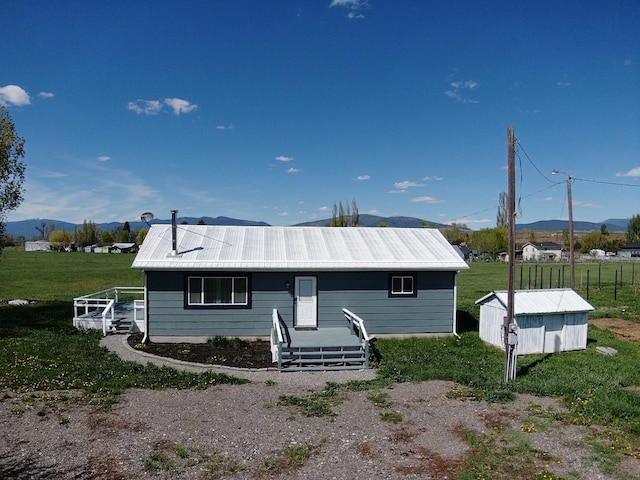 view of front of home featuring a mountain view, metal roof, and a front yard