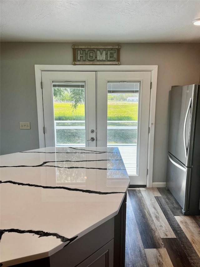 kitchen with freestanding refrigerator, dark wood-style flooring, french doors, light countertops, and baseboards
