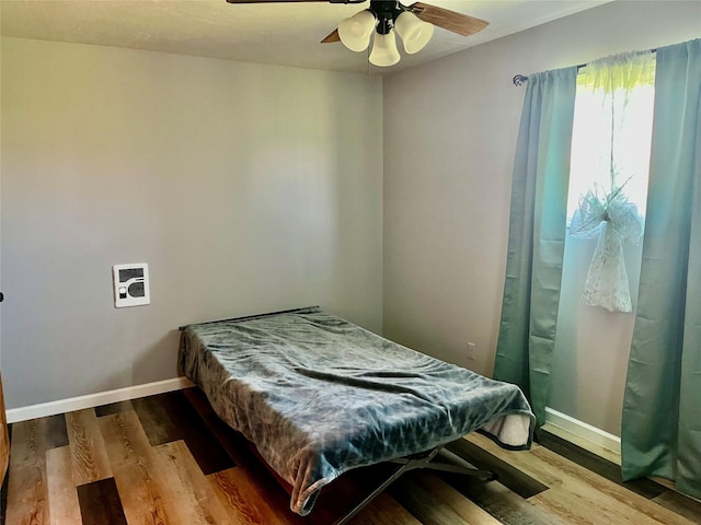 bedroom featuring wood finished floors, ceiling fan, and baseboards