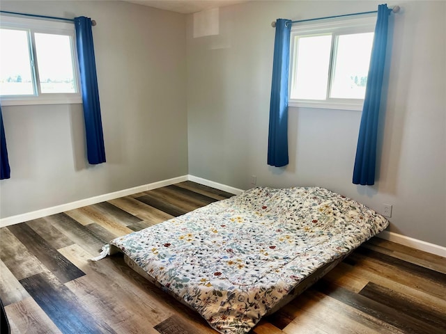 bedroom featuring wood finished floors and baseboards