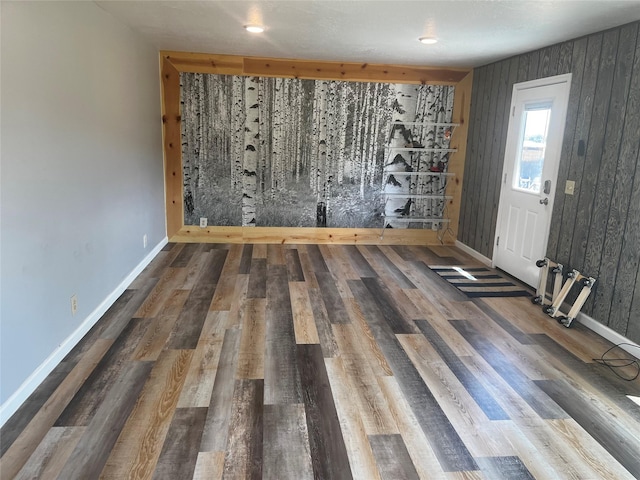 spare room with baseboards and wood finished floors