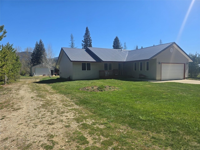 ranch-style house featuring concrete driveway, an attached garage, a front lawn, and metal roof