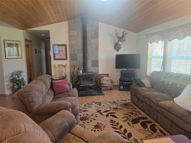 living area featuring a wood stove, vaulted ceiling, wood finished floors, and wooden ceiling