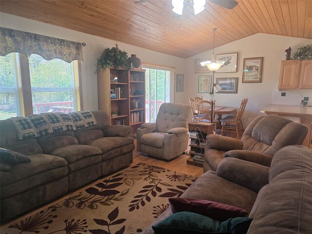 living area featuring lofted ceiling, light wood-type flooring, wooden ceiling, and ceiling fan