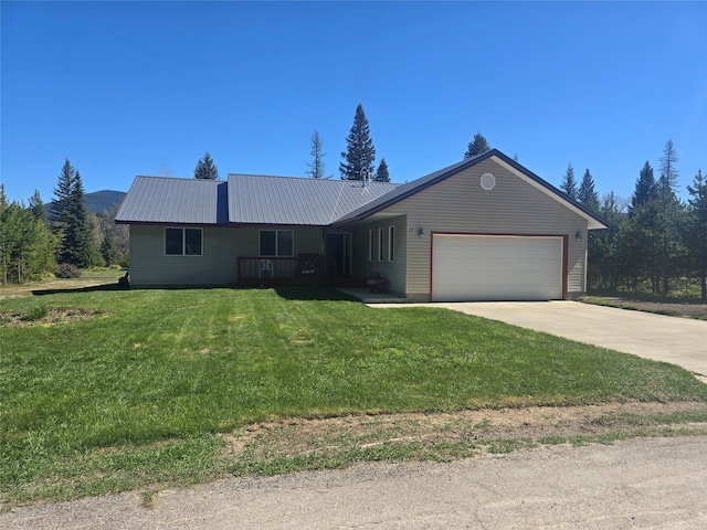 ranch-style home featuring an attached garage, a front lawn, metal roof, and concrete driveway