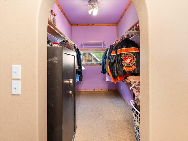 walk in closet featuring arched walkways and tile patterned floors