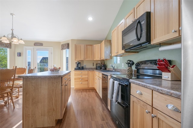 kitchen featuring black appliances, light brown cabinets, a kitchen island, light wood finished floors, and a sink