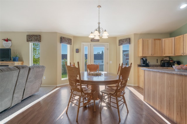 dining room featuring dark wood finished floors, a chandelier, and baseboards