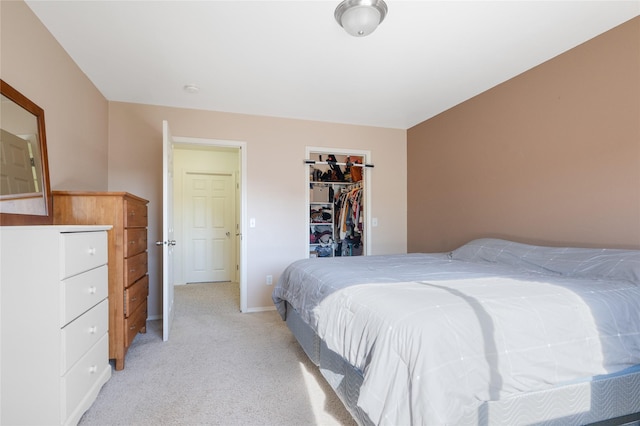 bedroom with light carpet, a walk in closet, baseboards, and a closet
