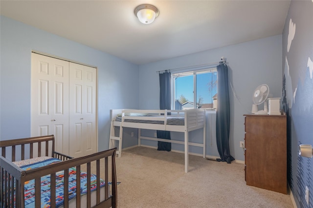 carpeted bedroom with a closet and baseboards