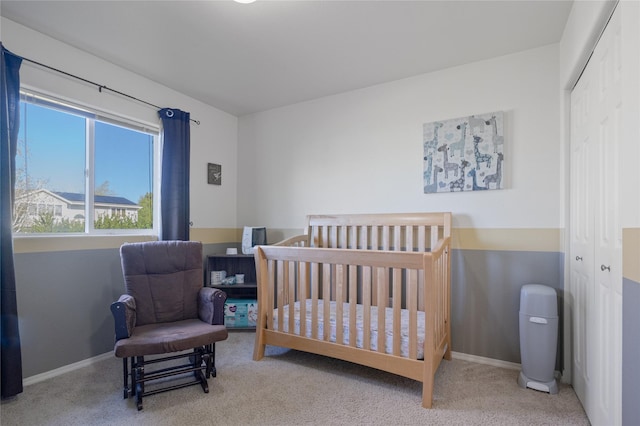 bedroom featuring carpet floors, a closet, baseboards, and a nursery area