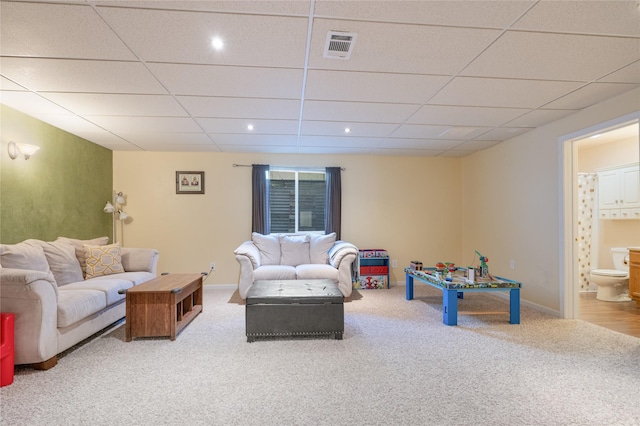 living area featuring carpet flooring, a paneled ceiling, and baseboards
