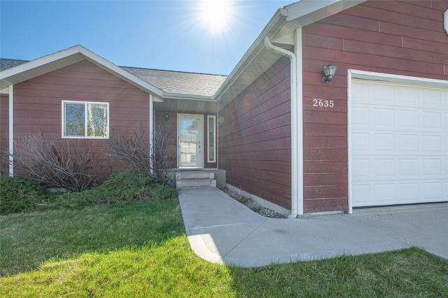 property entrance featuring a garage and a yard