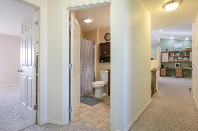 hall featuring light carpet and baseboards