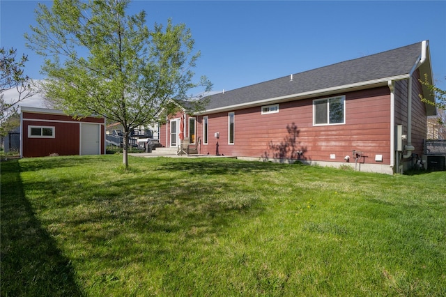 back of property with central air condition unit, a yard, an outbuilding, and a patio