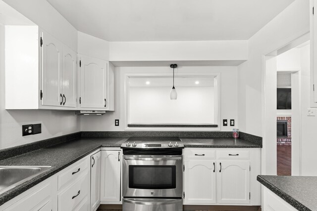 3024 8th Ave S, Great Falls, MT 59405 - kitchen with stainless steel electric range oven, dark countertops, white cabinetry, a sink, and pendant lighting