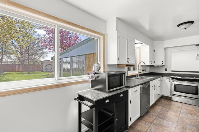 3024 8th Ave S, Great Falls, MT 59405 - kitchen featuring a sink, appliances with stainless steel finishes, white cabinetry, and dark countertops