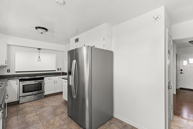 3024 8th Ave S, Great Falls, MT 59405 - kitchen with appliances with stainless steel finishes, dark countertops, white cabinetry, and baseboards