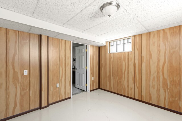 3024 8th Ave S, Great Falls, MT 59405 - basement with a paneled ceiling, wood walls, and baseboards