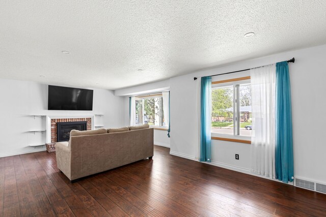 3024 8th Ave S, Great Falls, MT 59405 - living area with a textured ceiling, a brick fireplace, dark wood-style floors, and baseboards