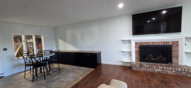 3024 8th Ave S, Great Falls, MT 59405 - living area featuring a fireplace, baseboards, wood finished floors, and a textured ceiling