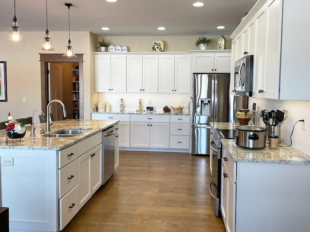 4195 Fox Hollow Dr, Helena, MT 59602 - kitchen with a sink, stainless steel appliances, white cabinets, decorative backsplash, and a center island with sink