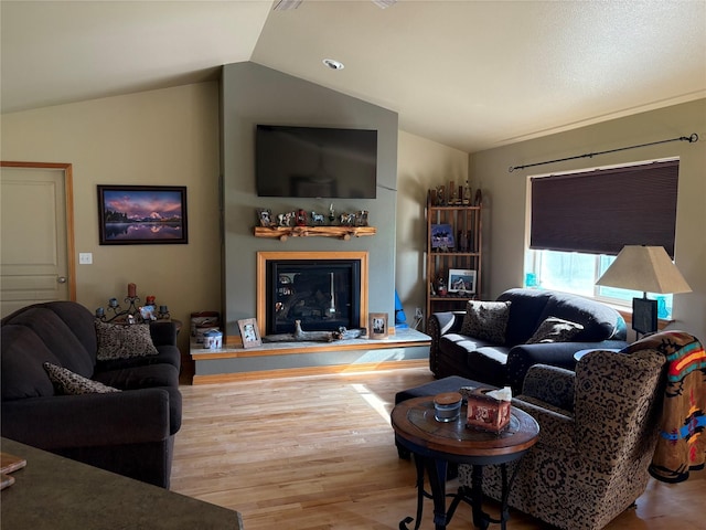 72822 Joes Ln, Arlee, MT 59821 - living area featuring vaulted ceiling, wood finished floors, and a glass covered fireplace