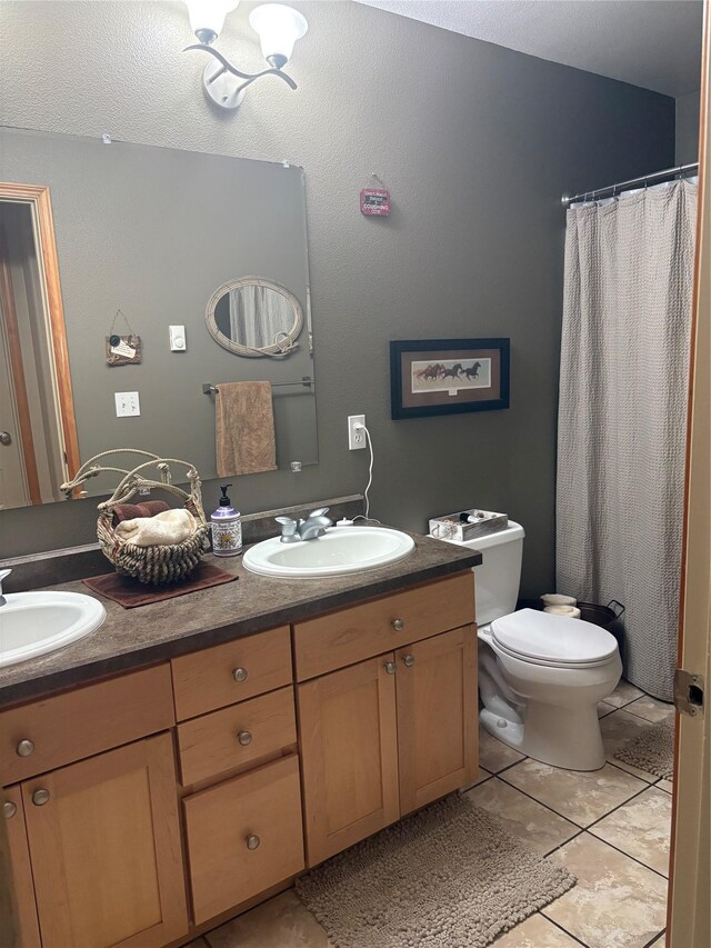 72822 Joes Ln, Arlee, MT 59821 - bathroom featuring tile patterned flooring, toilet, and double vanity