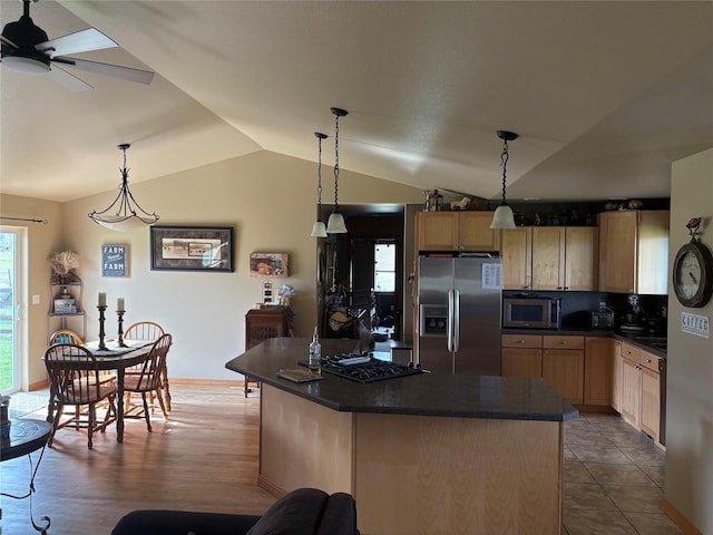 72822 Joes Ln, Arlee, MT 59821 - kitchen featuring stainless steel appliances, light brown cabinetry, dark countertops, lofted ceiling, and a kitchen island