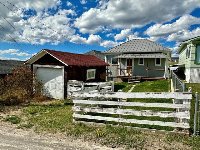 76 Missoula Ave, Butte, MT 59701 - view of front of house featuring a fenced front yard, a garage, an outdoor structure, metal roof, and a standing seam roof
