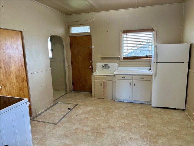 76 Missoula Ave, Butte, MT 59701 - kitchen with white appliances, arched walkways, light countertops, and a sink