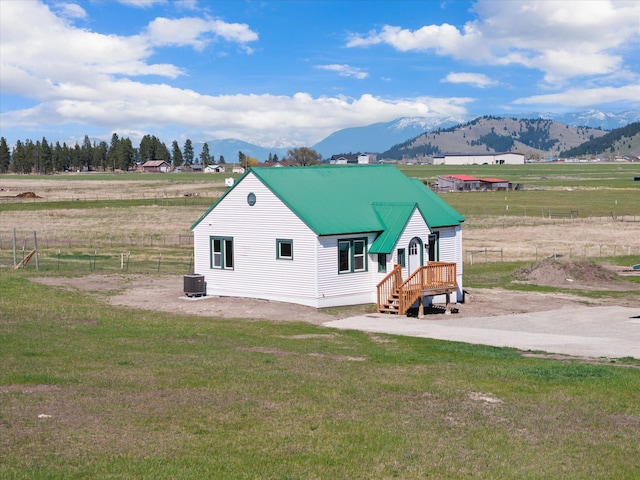 149 Vonderheide Ln, Kalispell, MT 59901 - rear view of house with a mountain view, a metal roof, and a view of countryside