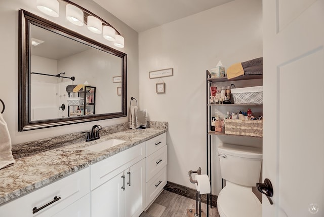 full bath with wood finished floors, toilet, vanity, and baseboards
