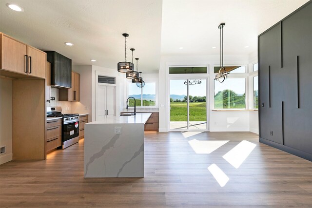 2736 Paniolo Pl, Missoula, MT 59808 - kitchen with stainless steel gas range, a sink, a chandelier, dark wood-type flooring, and recessed lighting