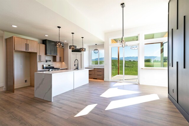 2736 Paniolo Pl, Missoula, MT 59808 - kitchen featuring stainless steel gas stove, light wood-style flooring, a sink, a chandelier, and recessed lighting