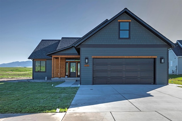 2736 Paniolo Pl, Missoula, MT 59808 - view of front facade featuring a front yard, concrete driveway, a mountain view, and a shingled roof