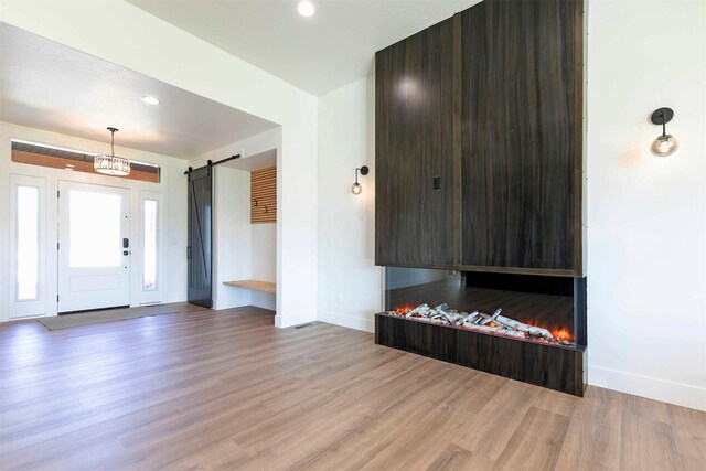 2736 Paniolo Pl, Missoula, MT 59808 - foyer entrance with wood finished floors, baseboards, a barn door, and recessed lighting