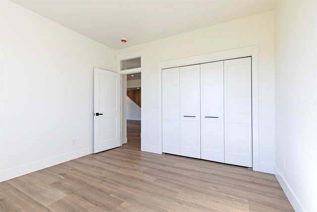 2736 Paniolo Pl, Missoula, MT 59808 - unfurnished bedroom featuring light wood-style flooring, baseboards, and a closet