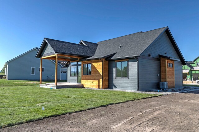 2736 Paniolo Pl, Missoula, MT 59808 - back of property with roof with shingles, a lawn, and central AC