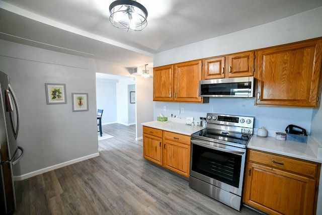 1536 Meadowlark Dr Unit 10B, Great Falls, MT 59404 - kitchen with appliances with stainless steel finishes, light countertops, brown cabinetry, and dark wood finished floors